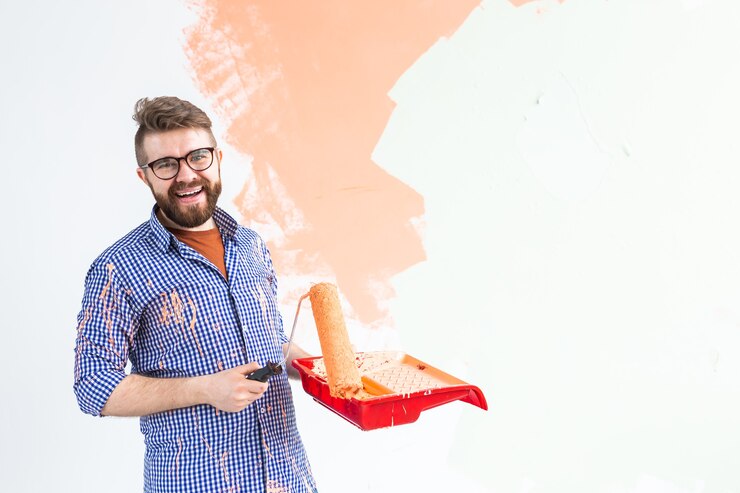 Painting Services happy man painting interior wall with paint roller new house guy with roller applying paint 230311 12112.jpg